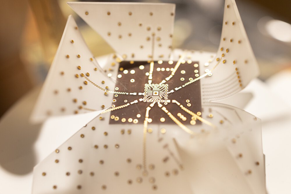 Close-up of an abstract sculpture at the LOPEC trade fair, consisting of dotted white and gold elements radiating from a central point.