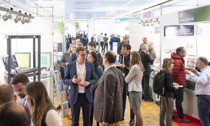 A well-attended LOPEC trade fair where people interact with each other in the exhibition space and explore the exhibitors' stands.