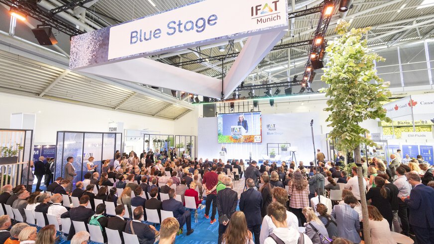 Teilnehmer einer Präsentation auf der Blue Stage während der IFAT Munich in einer großen Messehalle.